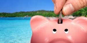 putting coin in piggy bank beach background 